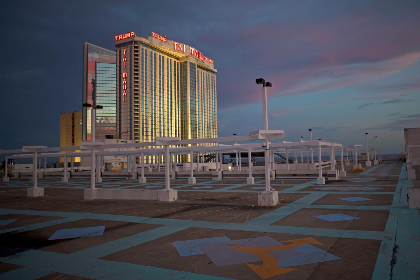 The illuminated Trump Taj Mahal Casino is seen from an empty rooftop parking lot at dusk in Atlantic City, New Jersey