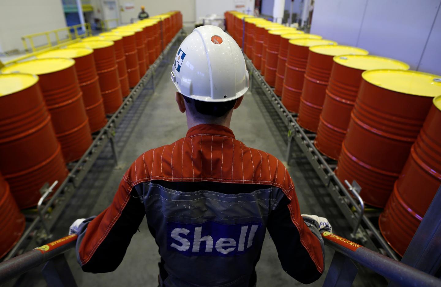 An employee stands in front of lines of oil barrels at Royal Dutch Shell Plc's lubricants blending plant in the town of Torzhok