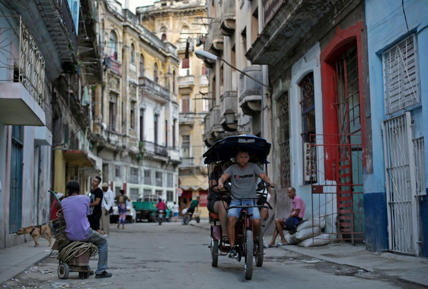 A man fetches passengers on his tricycle taxi in Havana