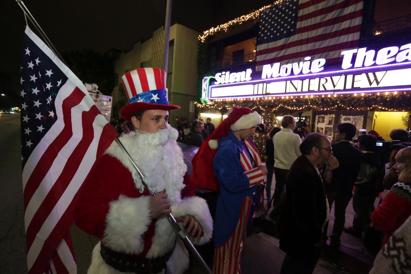 Ornstein holds an American flag as fans line up at the Silent Movie Theatre for a midnight screening of "The Interview" in Los Angeles, California
