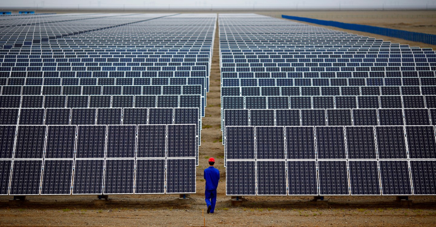 A worker inspects solar panels at a solar farm in Dunhuang, 950km northwest of Lanzhou, Gansu Province