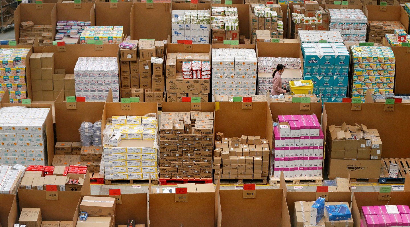 A member of staff pushes a trolley as she collects orders at the Amazon fulfilment centre in Peterborough