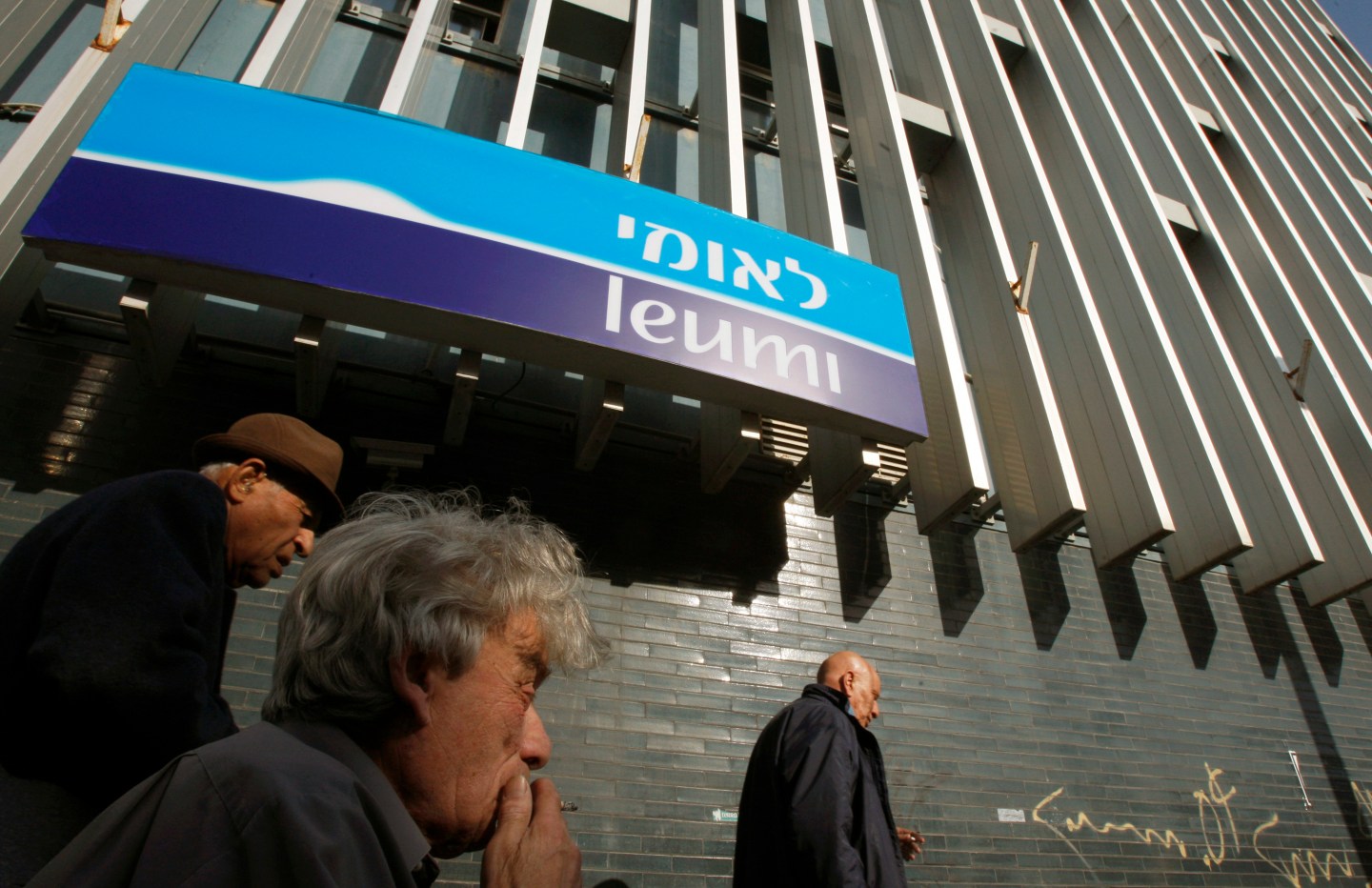Israelis walk past branch of Bank Leumi in Tel Aviv