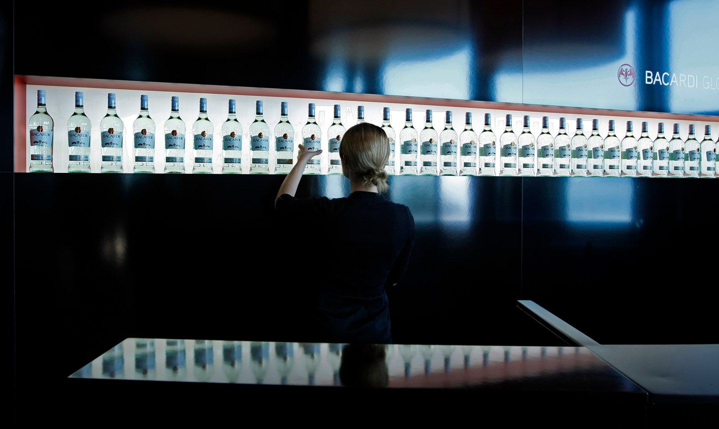 An exhibitor arranges Bacardi rum bottles during the TFWA exhibition in Cannes