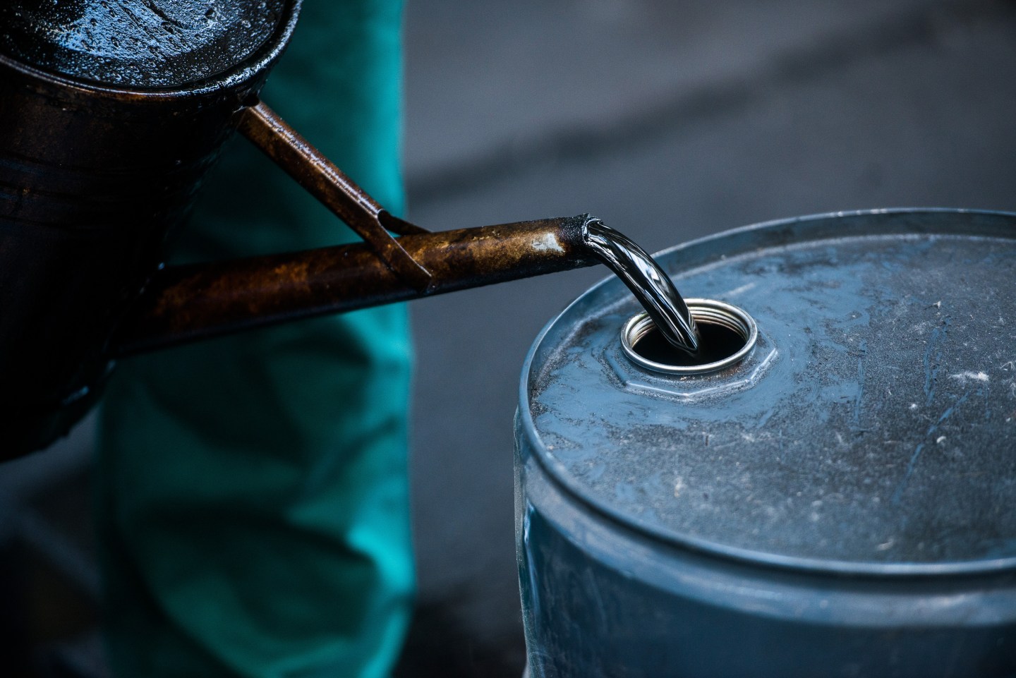 A worker pours liquid oil into a barrel at the delayed coker unit of the Duna oil refinery operated by MOL Hungarian Oil and Gas Plc in Szazhalombatta, Hungary, on Tuesday, July 9, 2013. Hungary refiner Mol may take part in oil exploration in Montenegro after country calls tender in July, daily Magyar Hirlap says. Photographer: Akos Stiller/Bloomberg