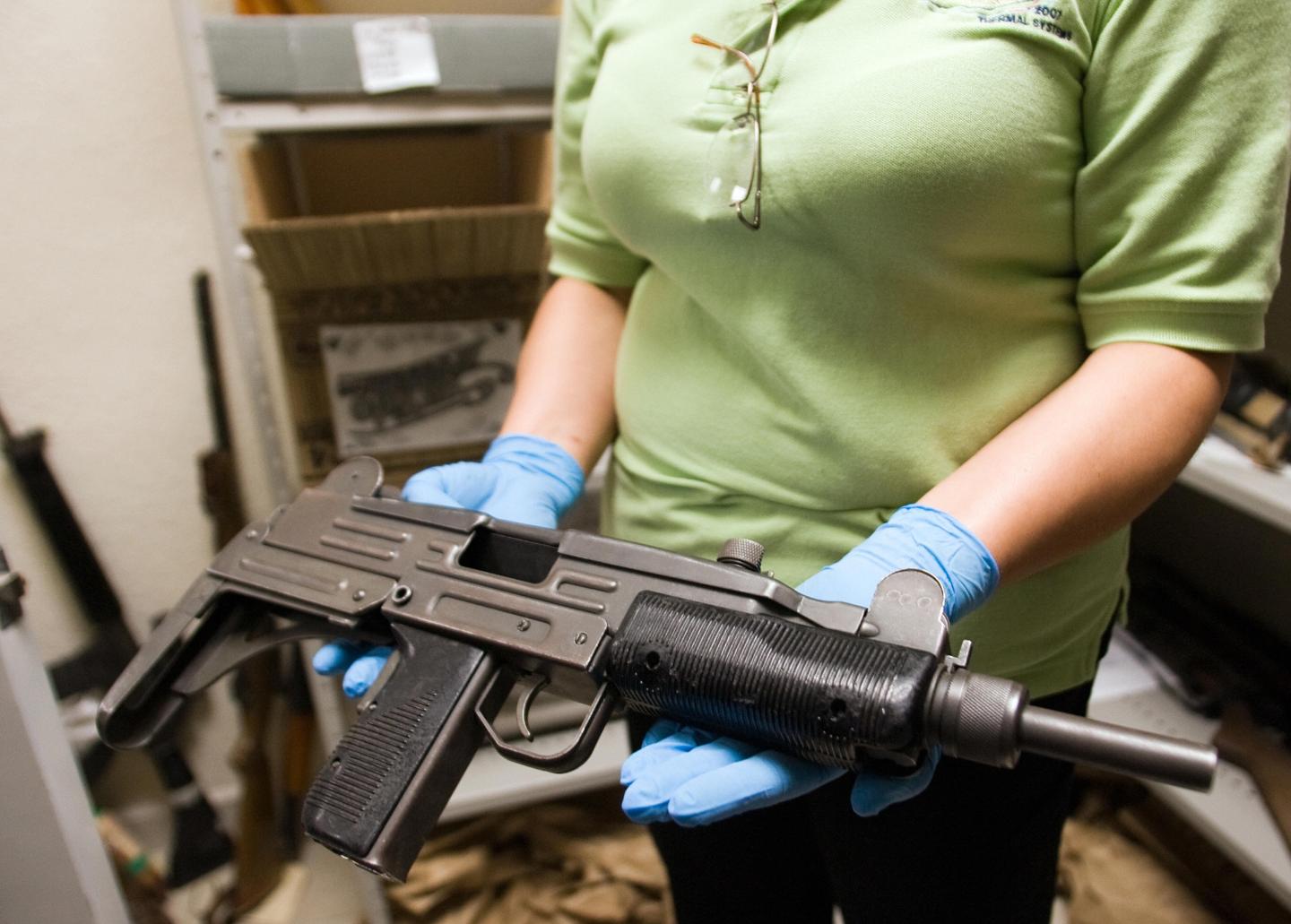A criminologist shows a "Uzi" submachine