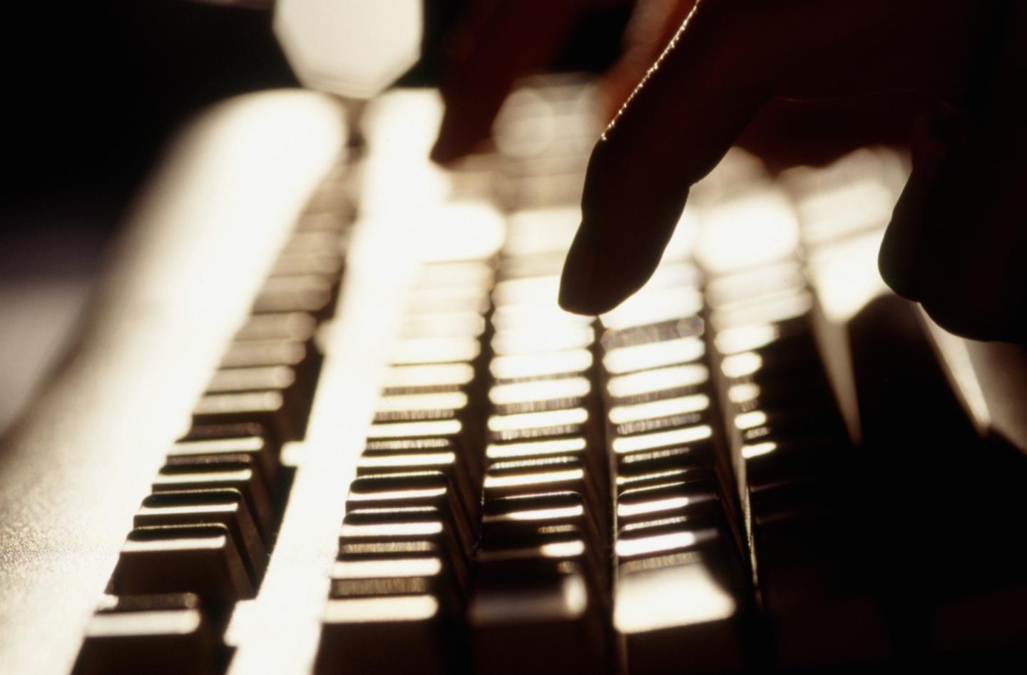 Woman typing on computer keyboard