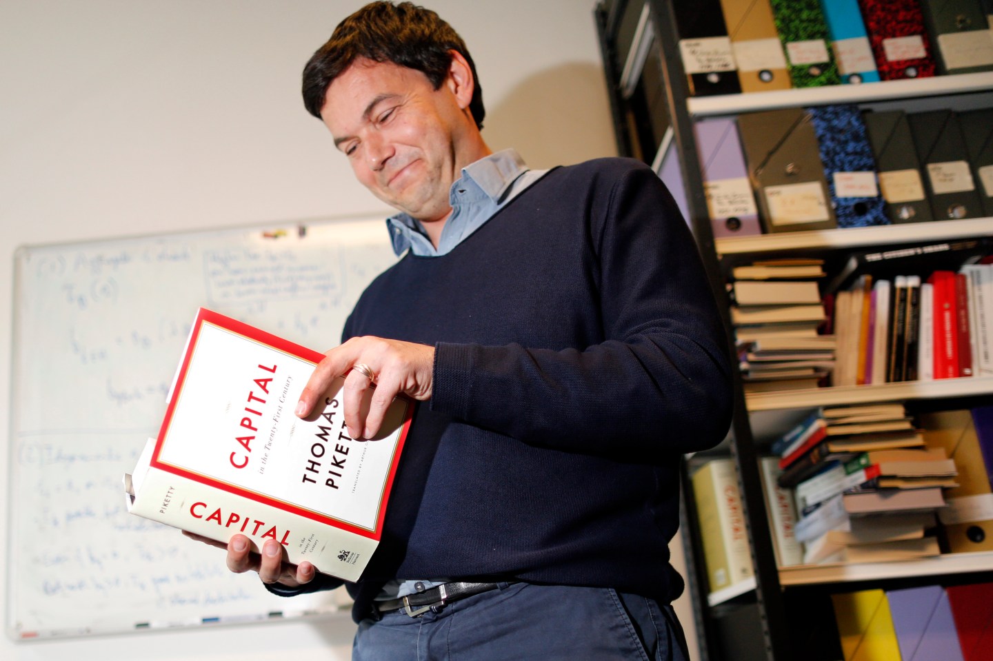 Thomas Piketty, French economist and academic, poses in his book-lined office at the French School for Advanced Studies in the Social Sciences (EHESS), in Paris