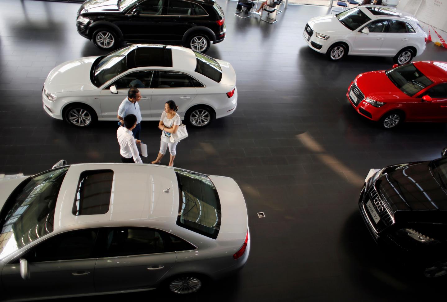 Customers look at a car inside an Audi dealership in Shanghai