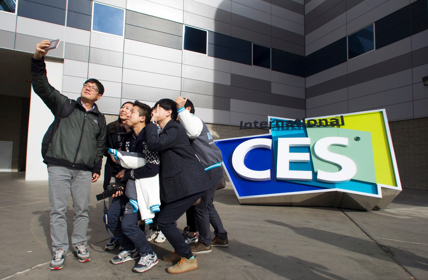 South Korean university students take a selfie in front of an International CES sign at the Las Vegas Convention Center in Las Vegas