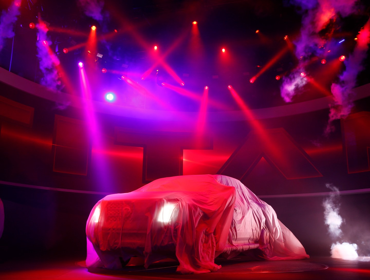 The 2016 Nissan Titan pickup truck is shown under a cover during its unveiling at the first press preview day of the North American International Auto Show in Detroit