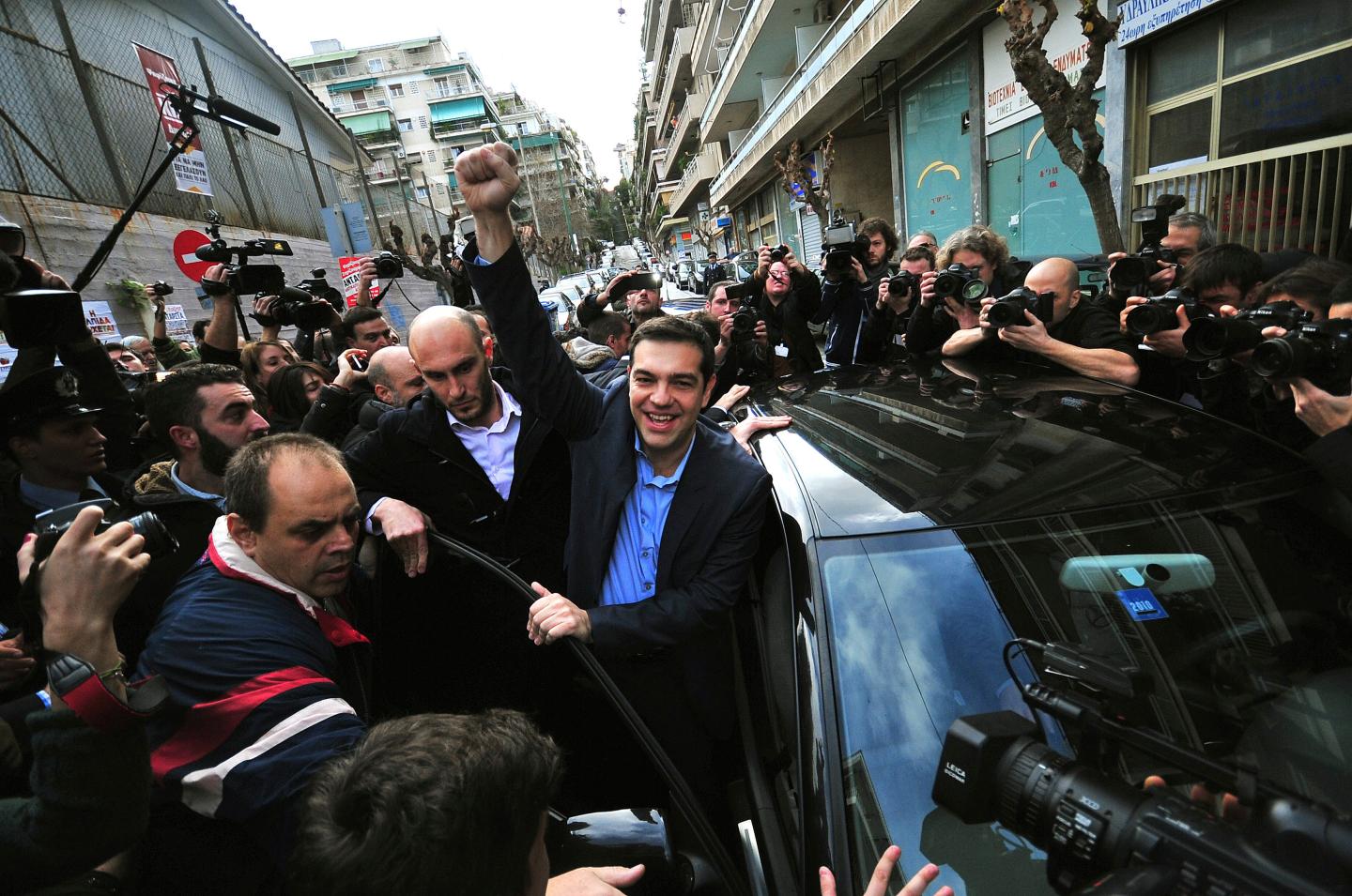 Opposition leader and head of radical leftist Syriza party Alexis Tsipras raises his fist as he leaves a polling station where he voted in Athens