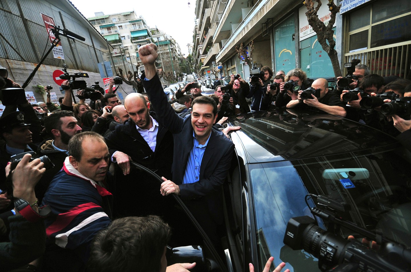 Opposition leader and head of radical leftist Syriza party Alexis Tsipras raises his fist as he leaves a polling station where he voted in Athens