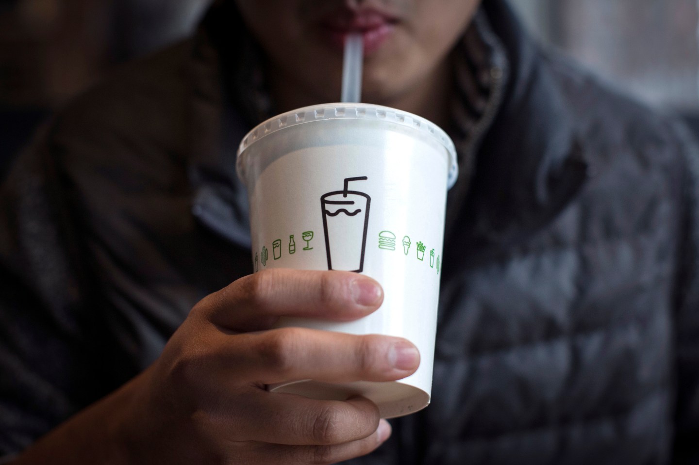 A man drinks a shake at Shake Shack in New York