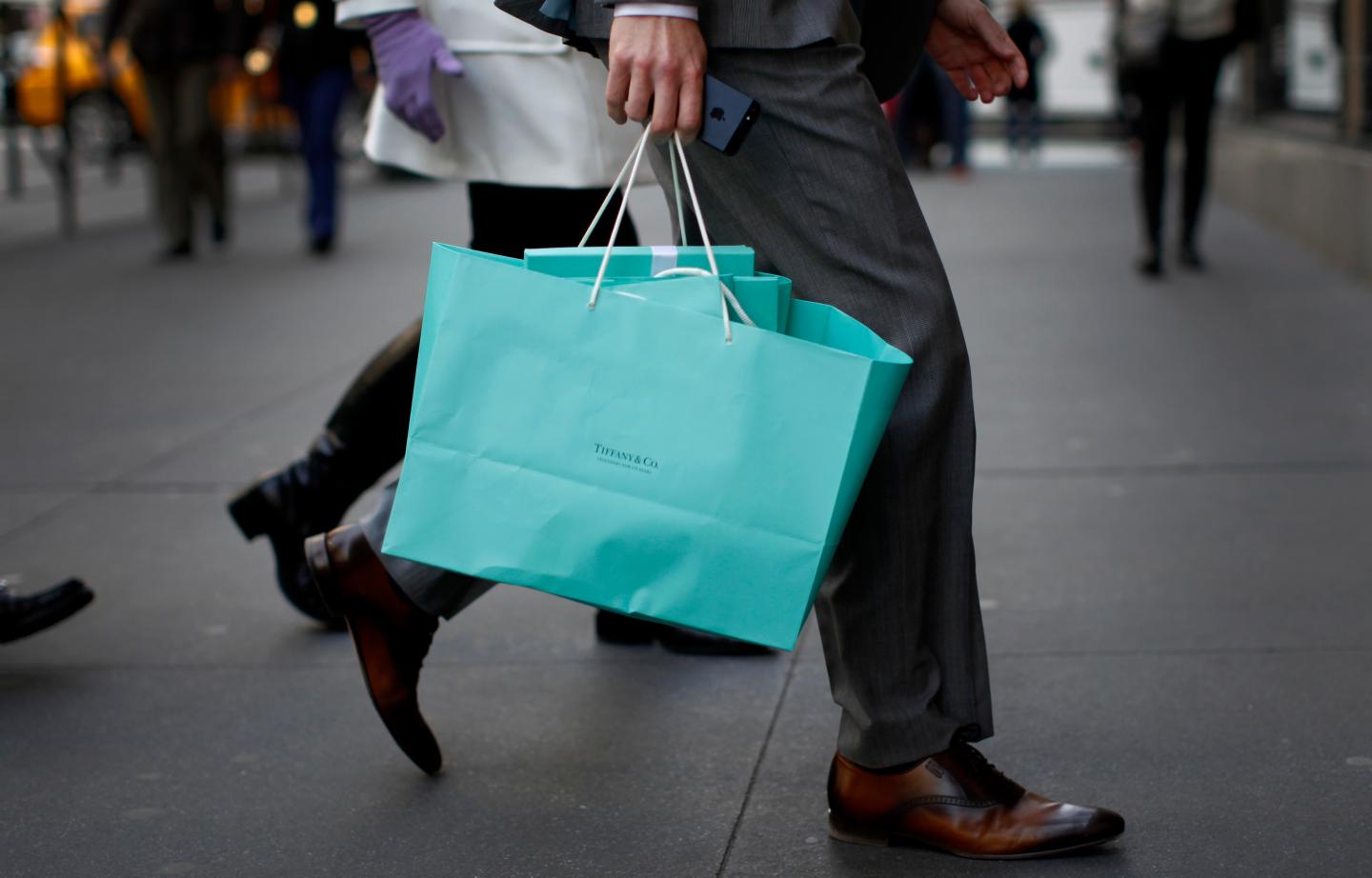 A shopper carries bags from Tiffany &amp; Co. jewelers along 5th Avenue in New York City