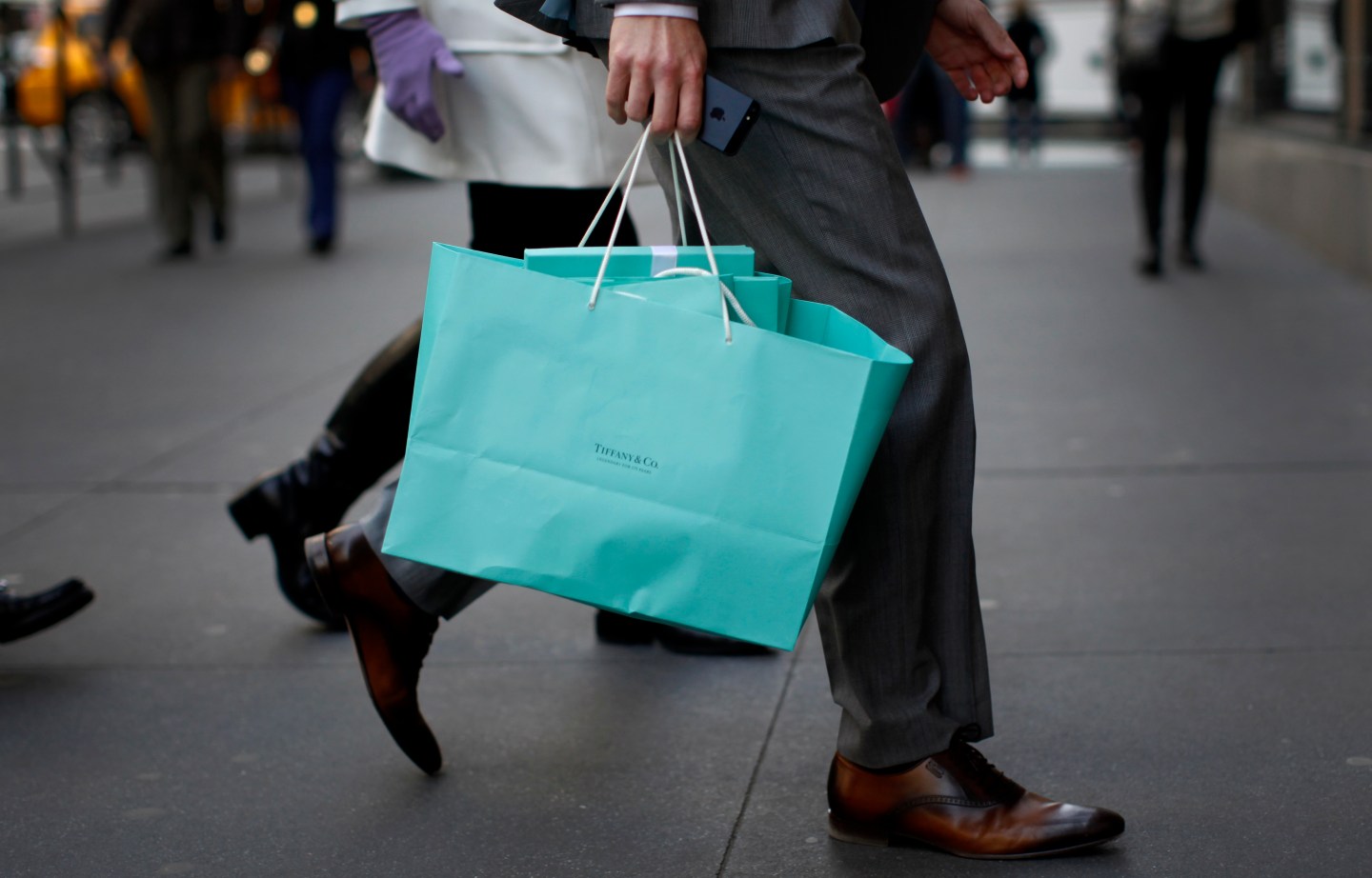 A shopper carries bags from Tiffany &amp; Co. jewelers along 5th Avenue in New York City