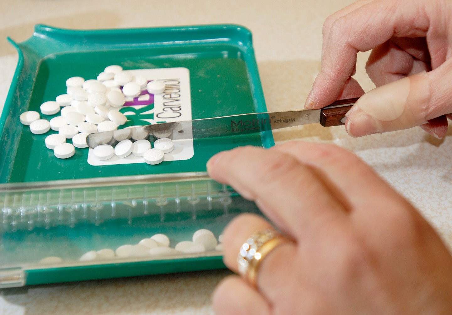 Pharmacy technician Andrea Tibbetts counts out pills to fill an order for generic medications at Por