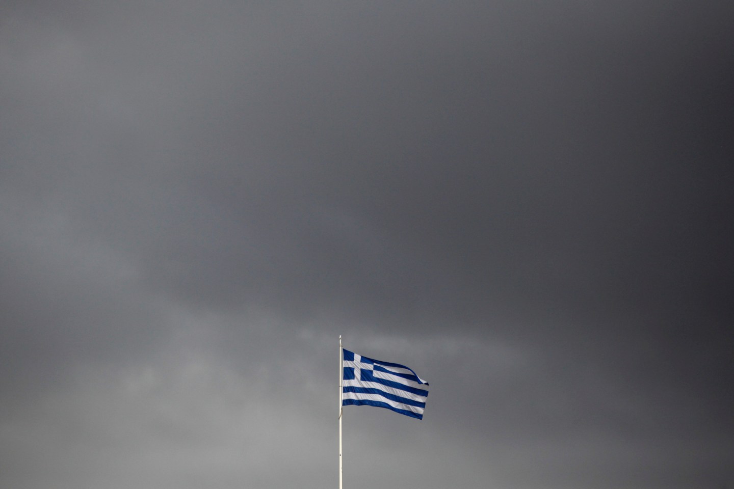 A European Union (EU) flag flies above the Greek parliament in Athens, Greece, on Tuesday, Feb. 24, 2015. Greece moved closer to winning an extension of financial aid after the head of the group of euro-region finance ministers said creditors were favorable toward the government’s package of new economic measures. Photographer: Kostas Tsironis/Bloomberg