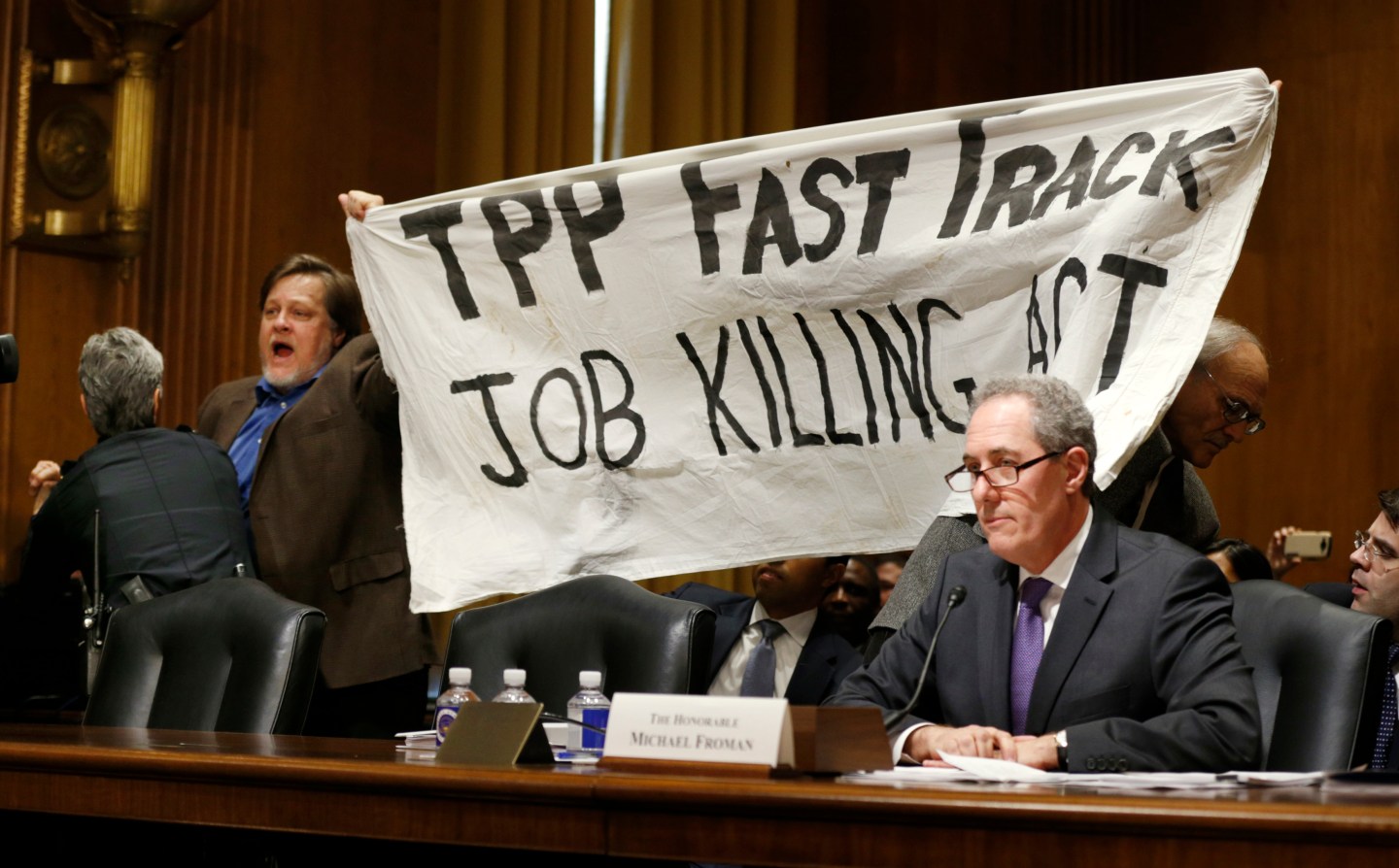 TPP protester holds up a sign during Froman trade hearing on Capitol Hill in Washington