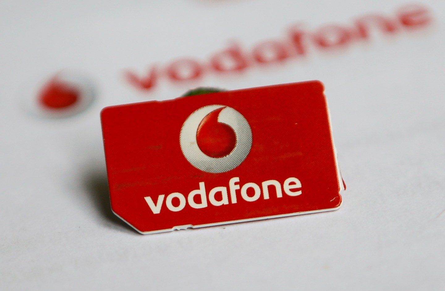 A SIM card of Vodafone is pictured in front of a letter of Vodafone in Dortmund