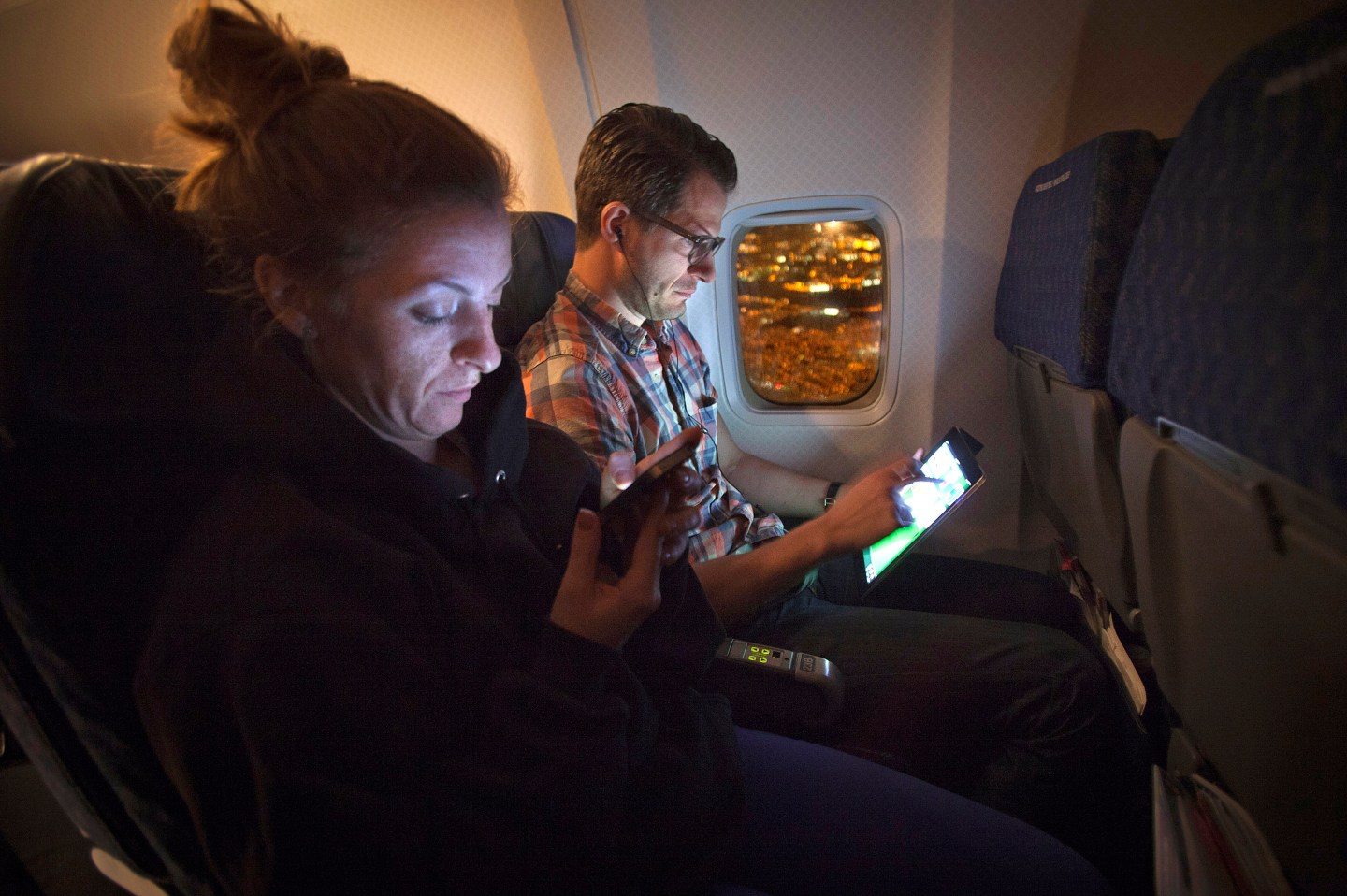 People use their smart devices on an American Airlines airplane, which is equipped with Gogo Inflight Internet service, enroute from Miami to New York