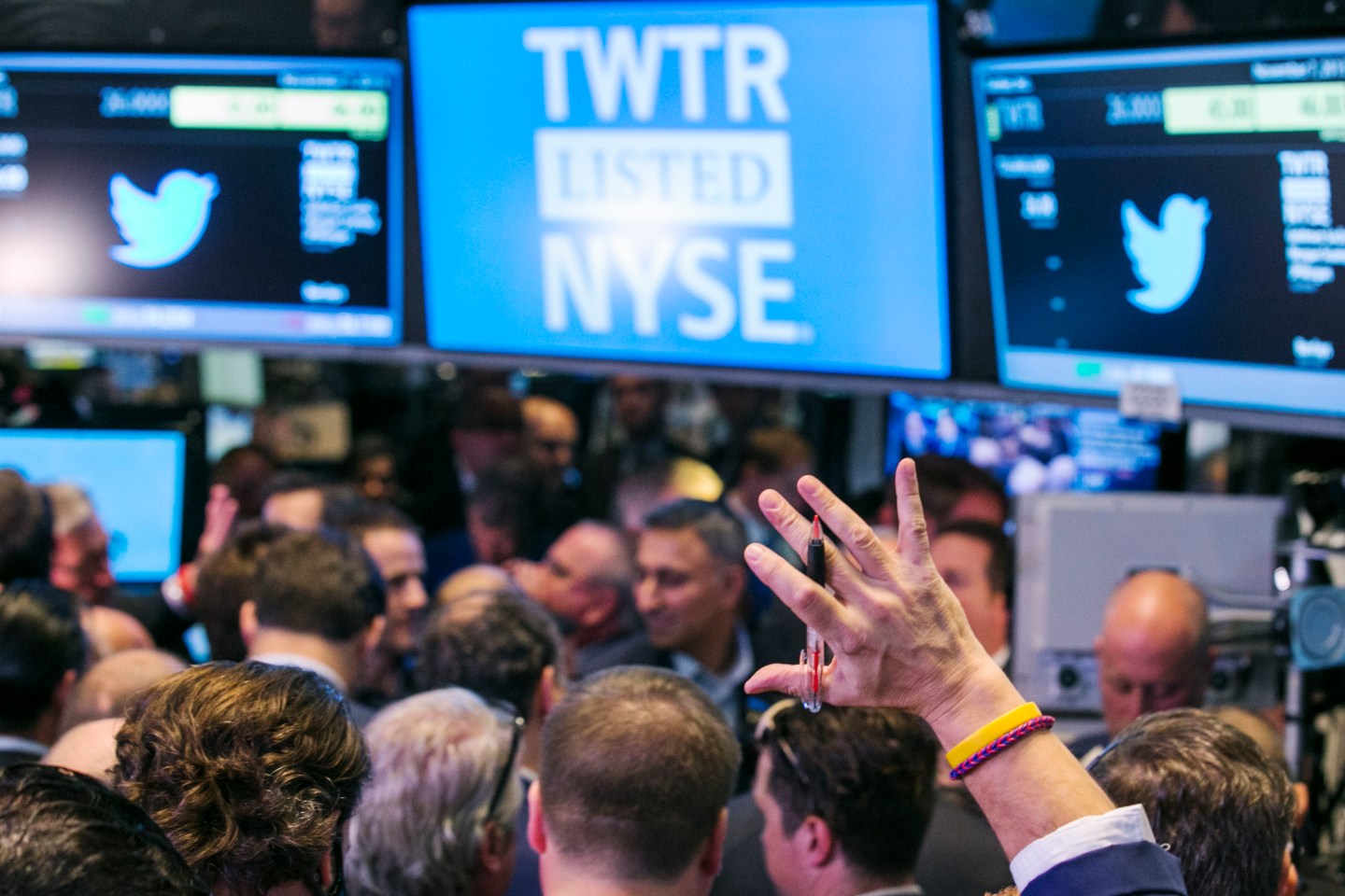 A trader raises his hand just before the Twitter Inc. IPO begins on the floor of the New York Stock Exchange in New York
