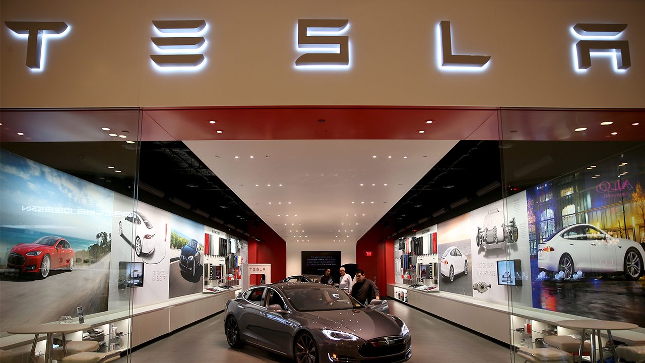 People look at a Tesla Motors vehicle on the showroom floor at the Dadeland Mall in Miami, Fla., Feb. 19, 2014. Joe Raedle/Getty Images