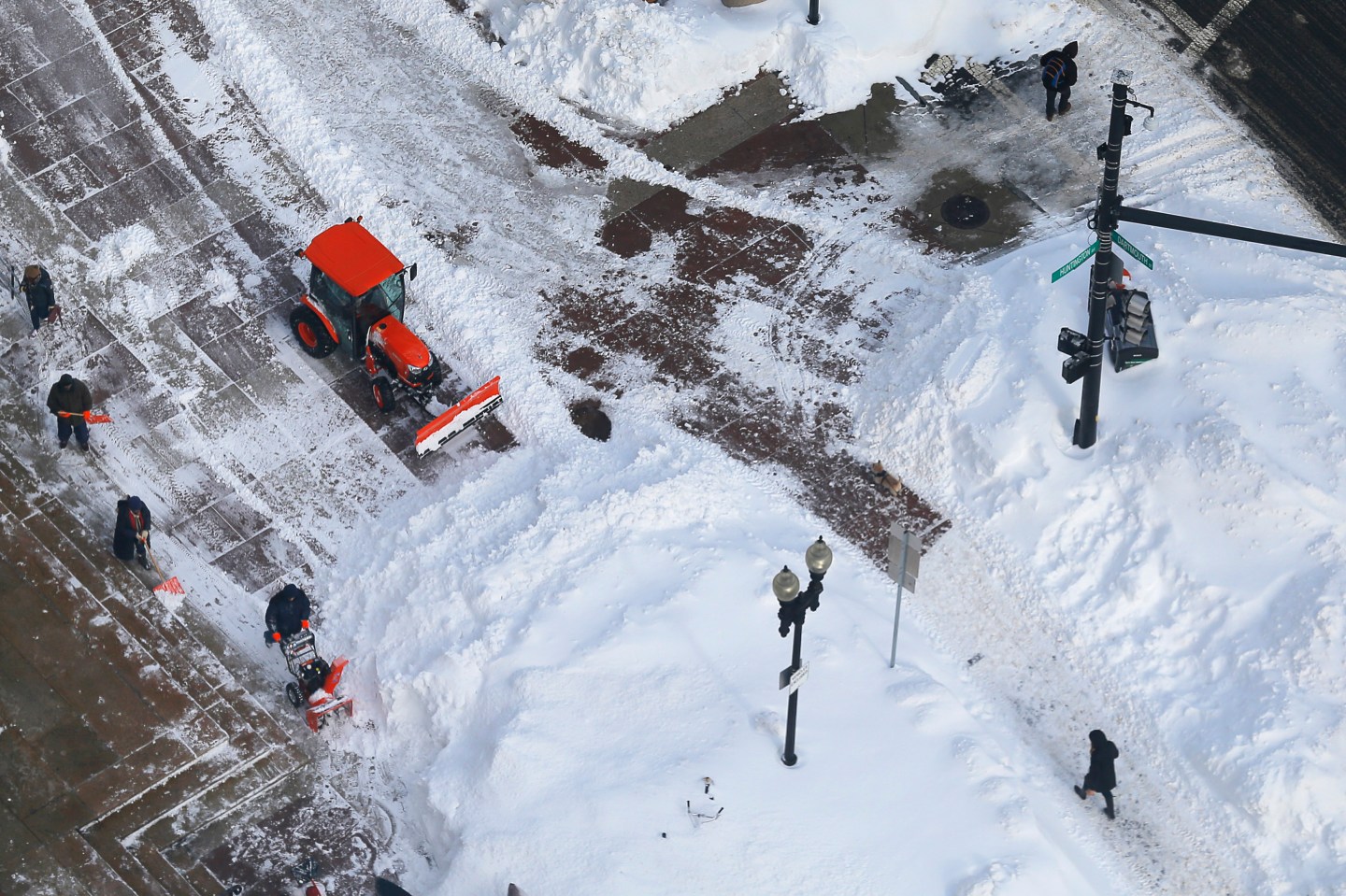 Crews work to clear sidewalks following a winter blizzard in Boston