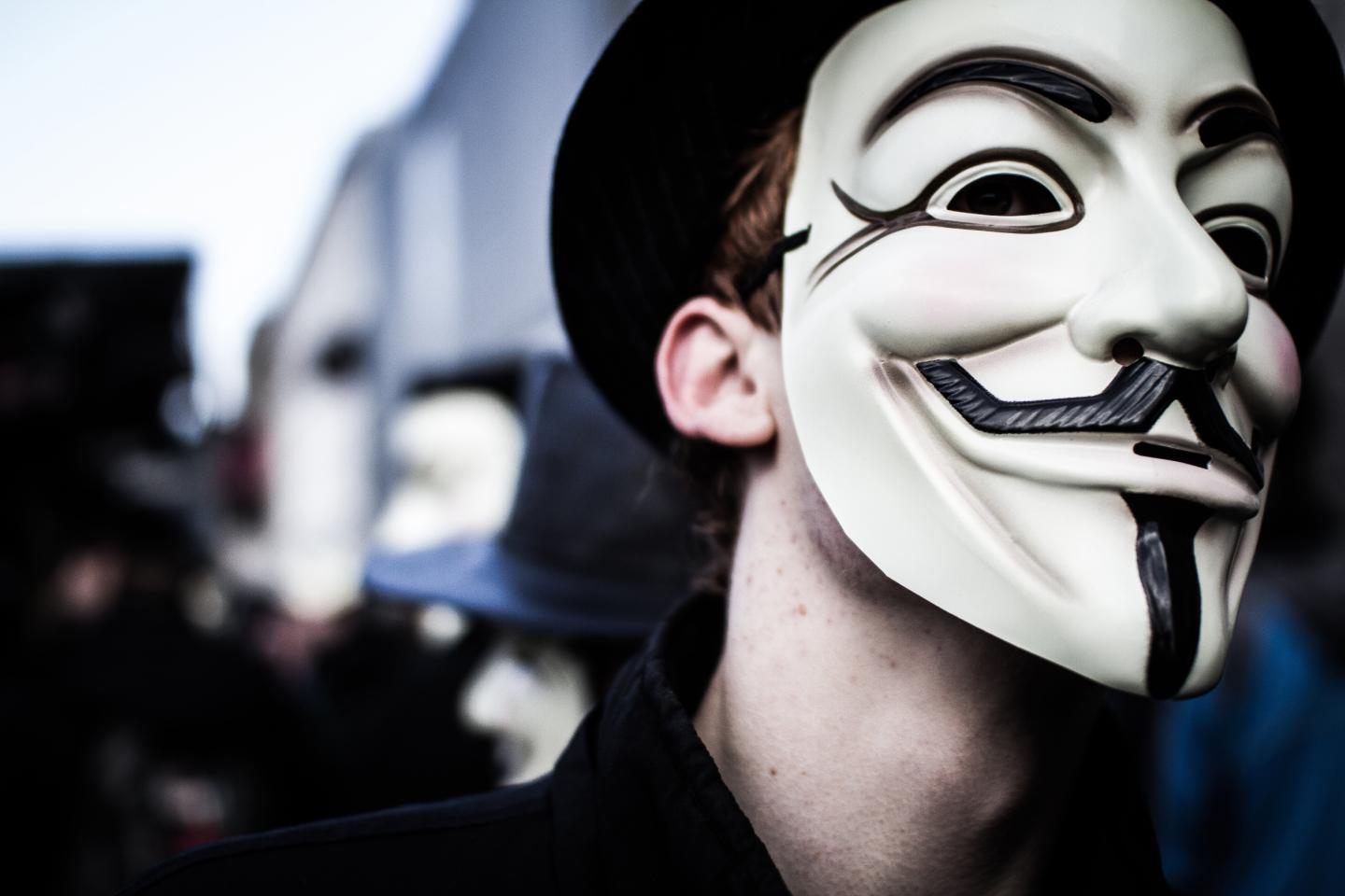 Person wears a Guy Fawkes mask which today is a trademark and symbol for the online hacktivist group Anonymous. 2012.