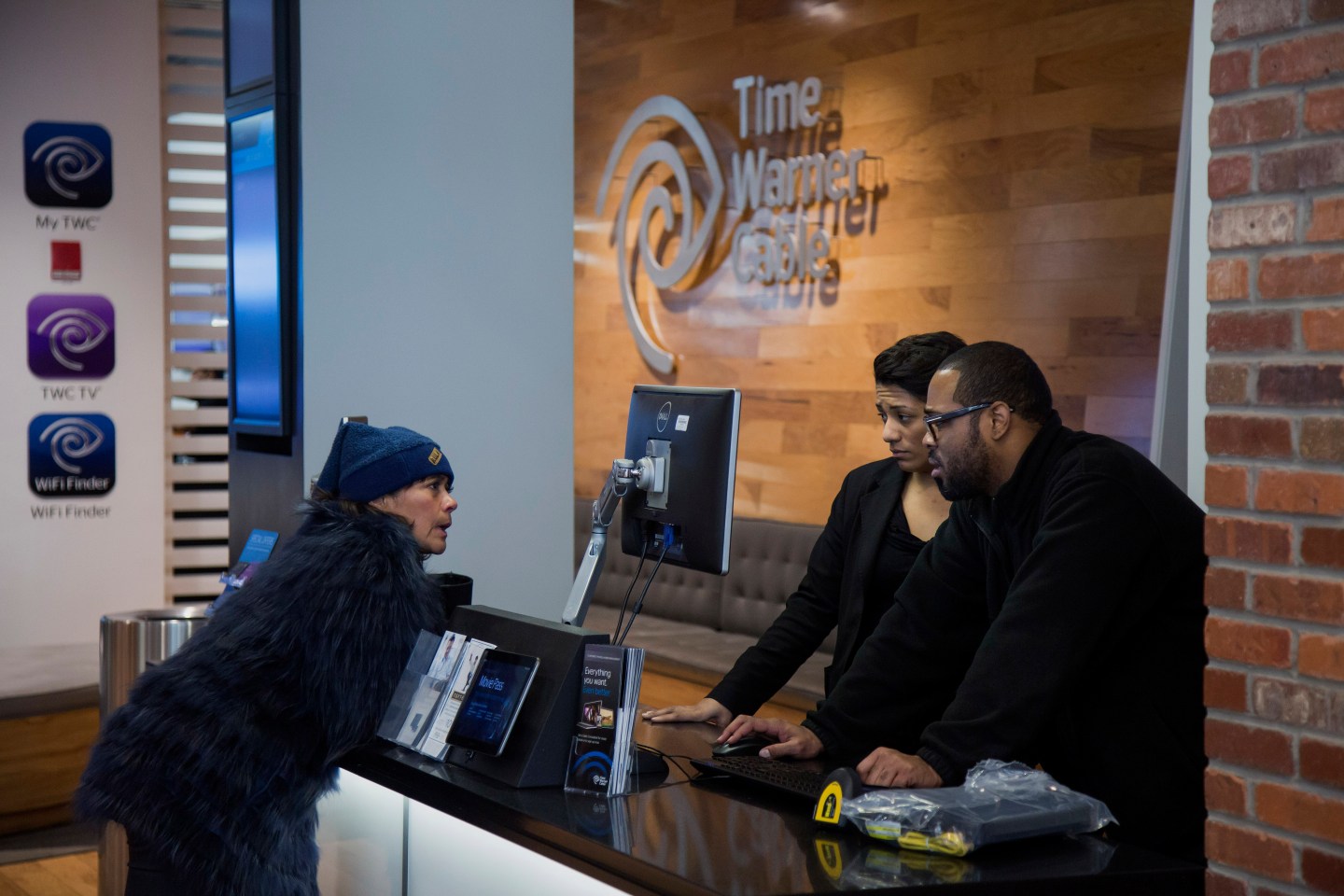 Time Warner Cable Inc. employees helps a customer inside the Time Warner Cable Inc. store in New York, N.Y., U.S., on Wednesday, January 28, 2015. Photographer: Michael Nagle/Bloomberg