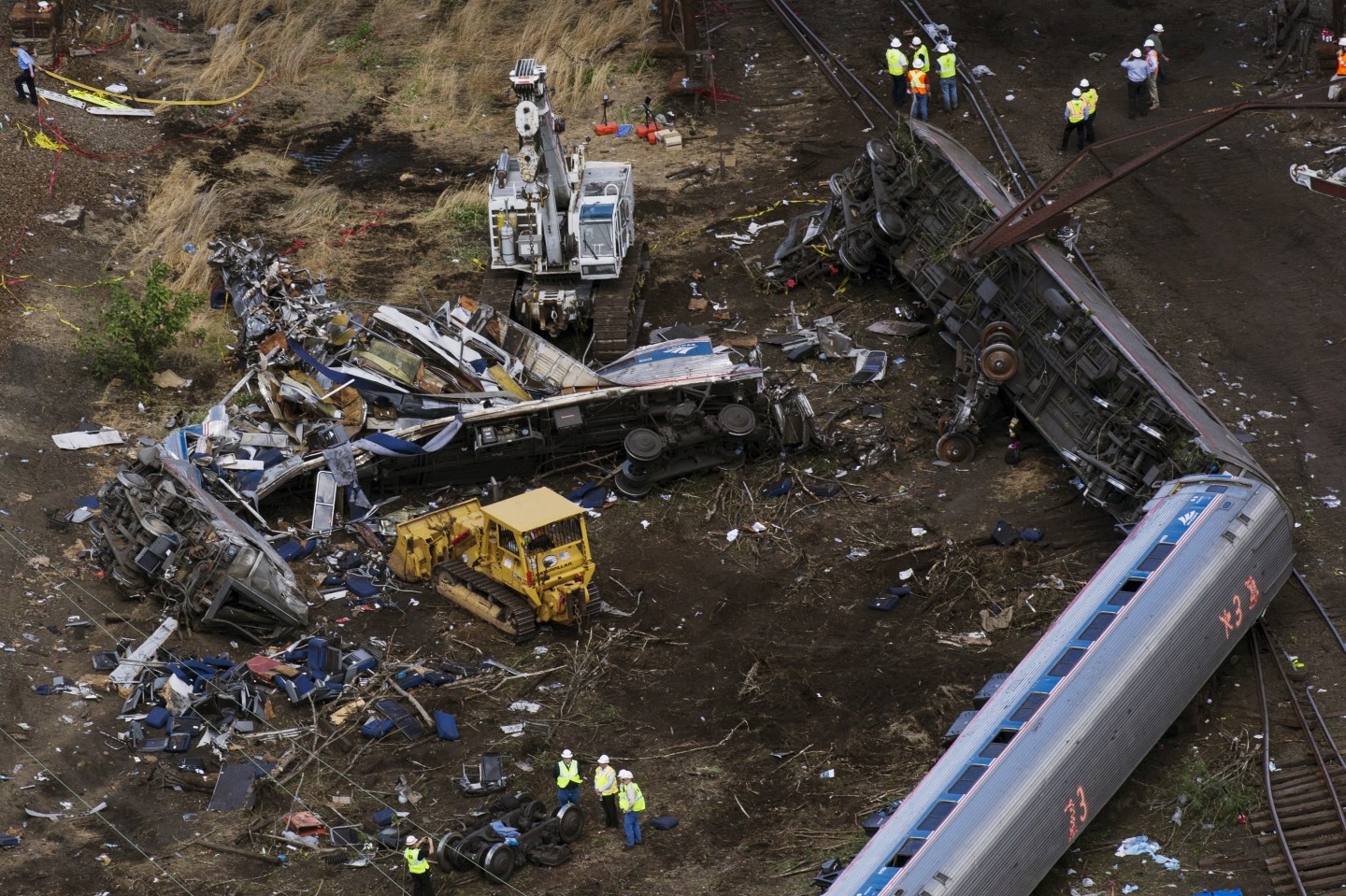 Emergency workers and Amtrak personnel inspect a derailed Amtrak train in Philadelphia, Pennsylvania