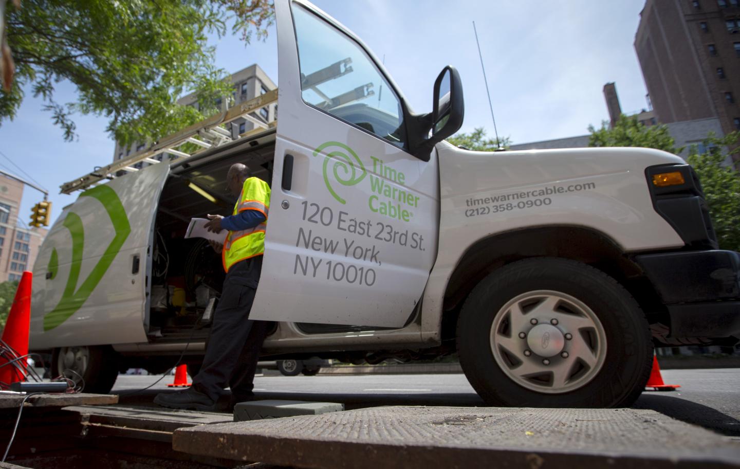 A Time Warner Cable service technician works on cable service from a van parked on the Upper West side of the Manhattan borough of New York City