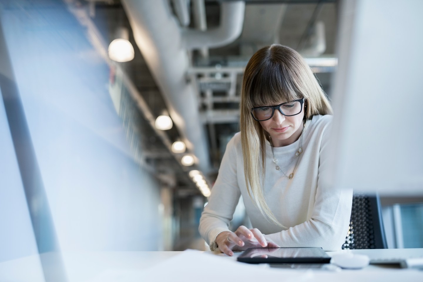 Businesswoman using digital tablet at office desk