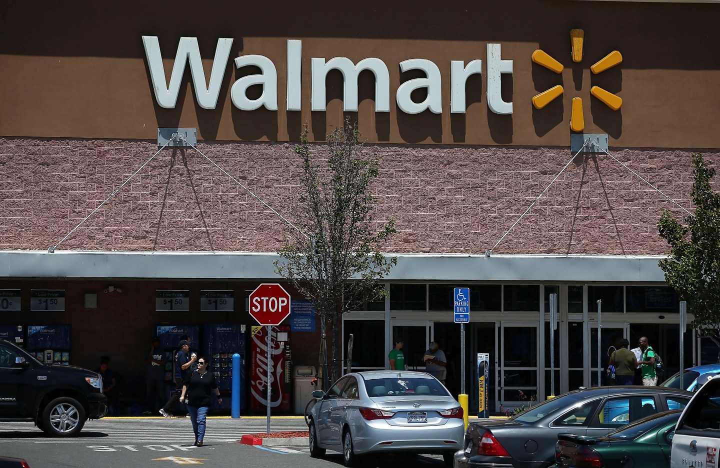 OAKLAND, CA - JUNE 11: Customers leave a Wal-Mart store on June 11, 2015 in Oakland, California. A federal judge has ruled that Wal-Mart failed to pay the California minimum wage to truck drivers and could have to pay $100 million in back pay. (Photo by Justin Sullivan/Getty Images)