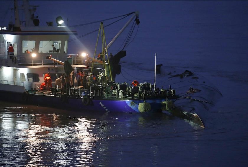 A rescue ship and workers are seen around a sunken ship in the Jianli section of Yangtze River, Hubei province