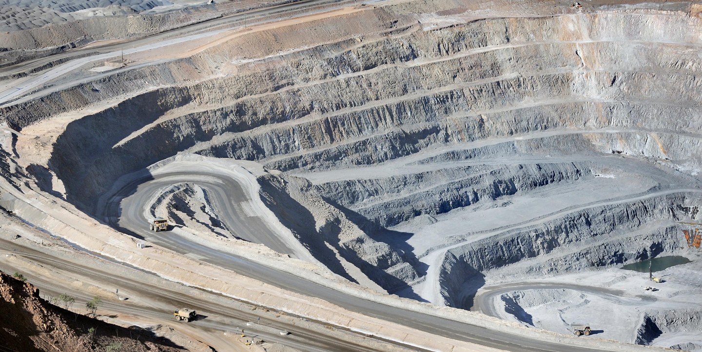 Trucks and heavy earth moving equipment operate inside Xstra