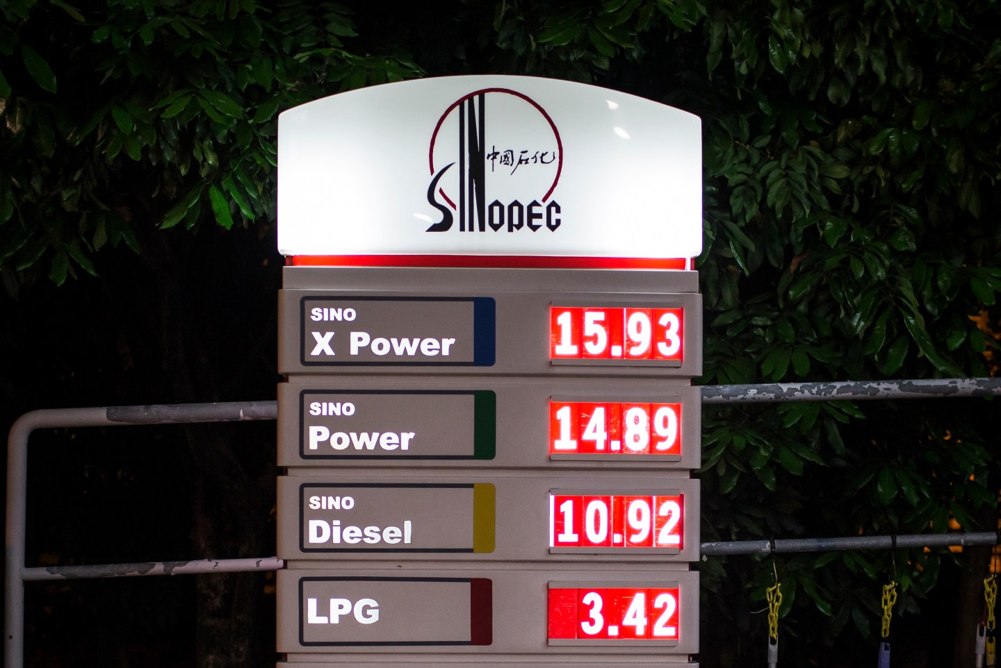 Caption:The China Petroleum &amp; Chemical Corp. (Sinopec) logo and oil prices are illuminated at night at one of the company's gas stations in Hong Kong, China, on Thursday, March 19, 2015. Sinopec, Asia's biggest oil refiner, is scheduled to release full year results today. Photographer: Billy H.C. Kwok/Bloomberg via Getty Images
