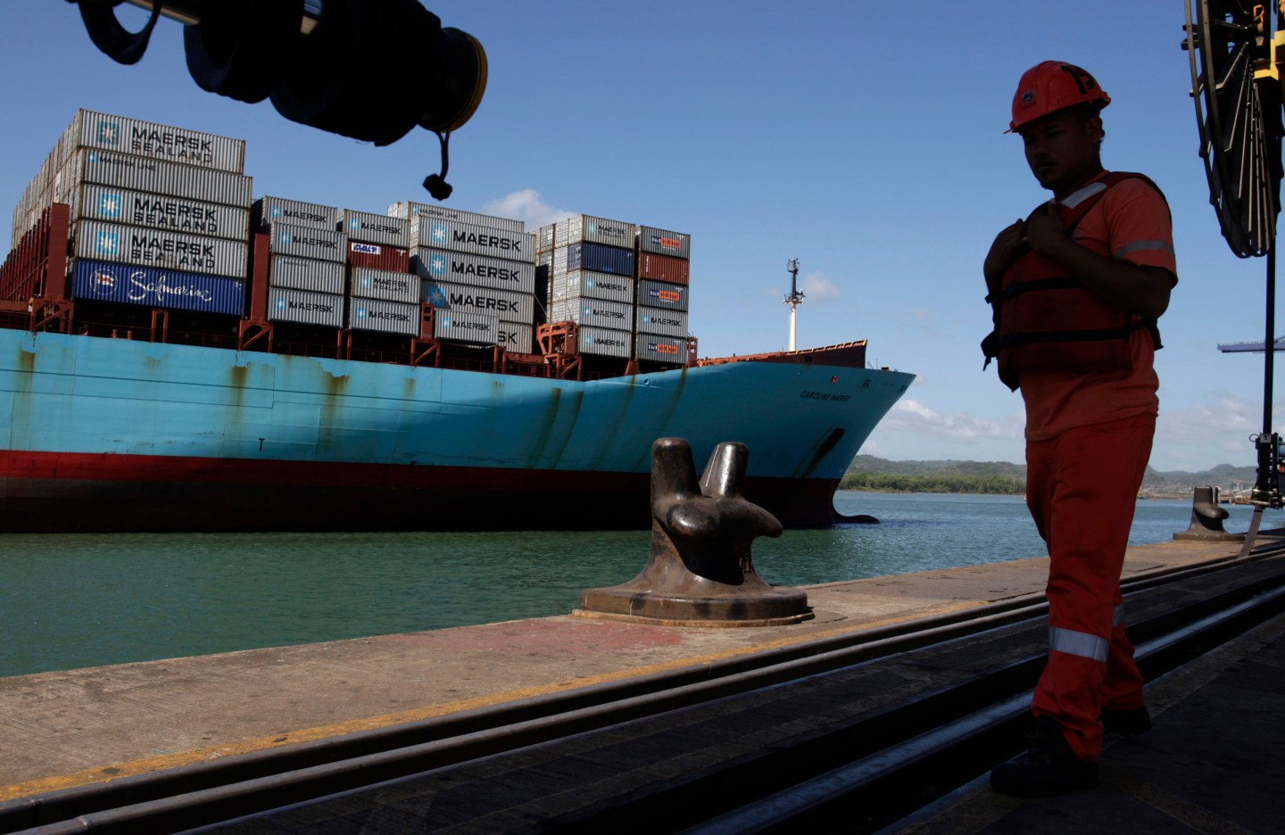 A worker is seen as a Post-Panamax ship passes by the pacific side of the Panama Canal in Panama City