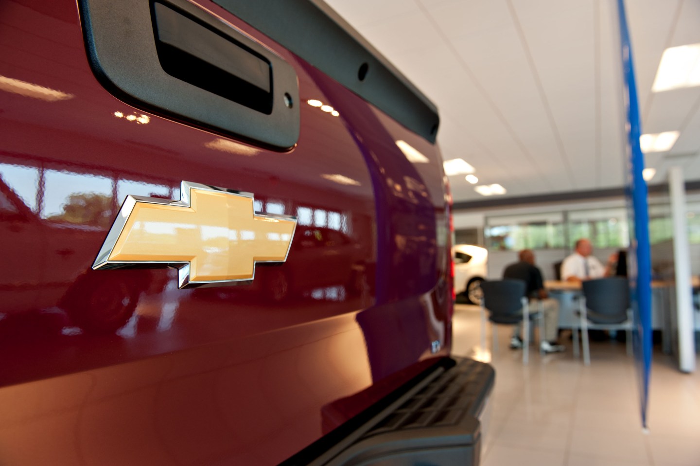 A customer talks with a sales person near a Chevrolet truck on display in the showroom of a General Motors Co. dealership in Peoria, Illinois, U.S.
