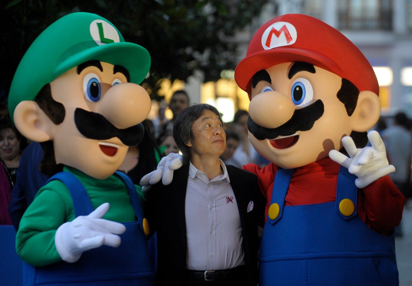 Japanese video game designer Shigeru Miyamoto poses with arcade game stars Mario Bros and Luigi at the Jovellanos Theatre in Gijon.