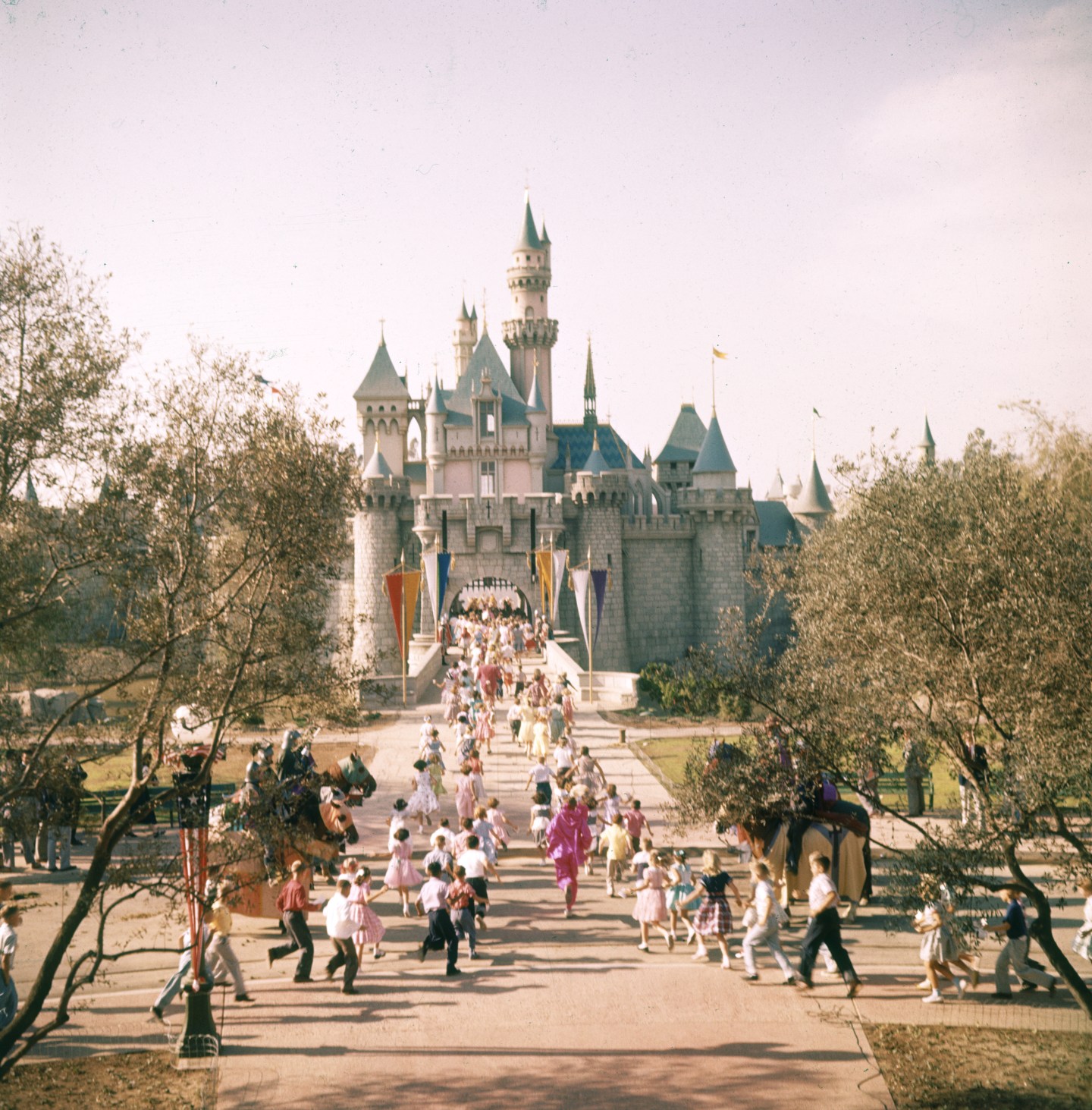 Subject: People running to Disneyland castle at Disneyland Amusement Park. Anaheim, California 1955Photographer- Loomis DeanTime Inc OwnedMerlin- 1201478
