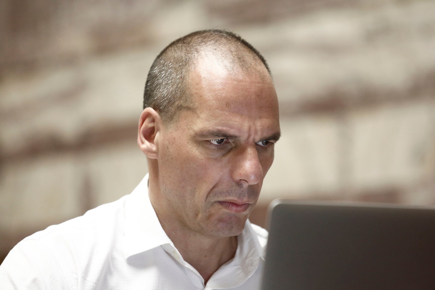 Yanis Varoufakis, former Greek finance minister, looks at a laptop screen inside the Greek parliament building in Athens, Greece, on Friday, July 10, 2015. In an 11th-hour bid to stay in the euro, the government of Greek Prime Minister Alexis Tsipras offered to meet most of the demands made by creditors in exchange for a bailout of 53.5 billion euros ($59.4 billion). Photographer: Kostas Tsironis/Bloomberg *** Local Caption *** Yanis Varoufakis