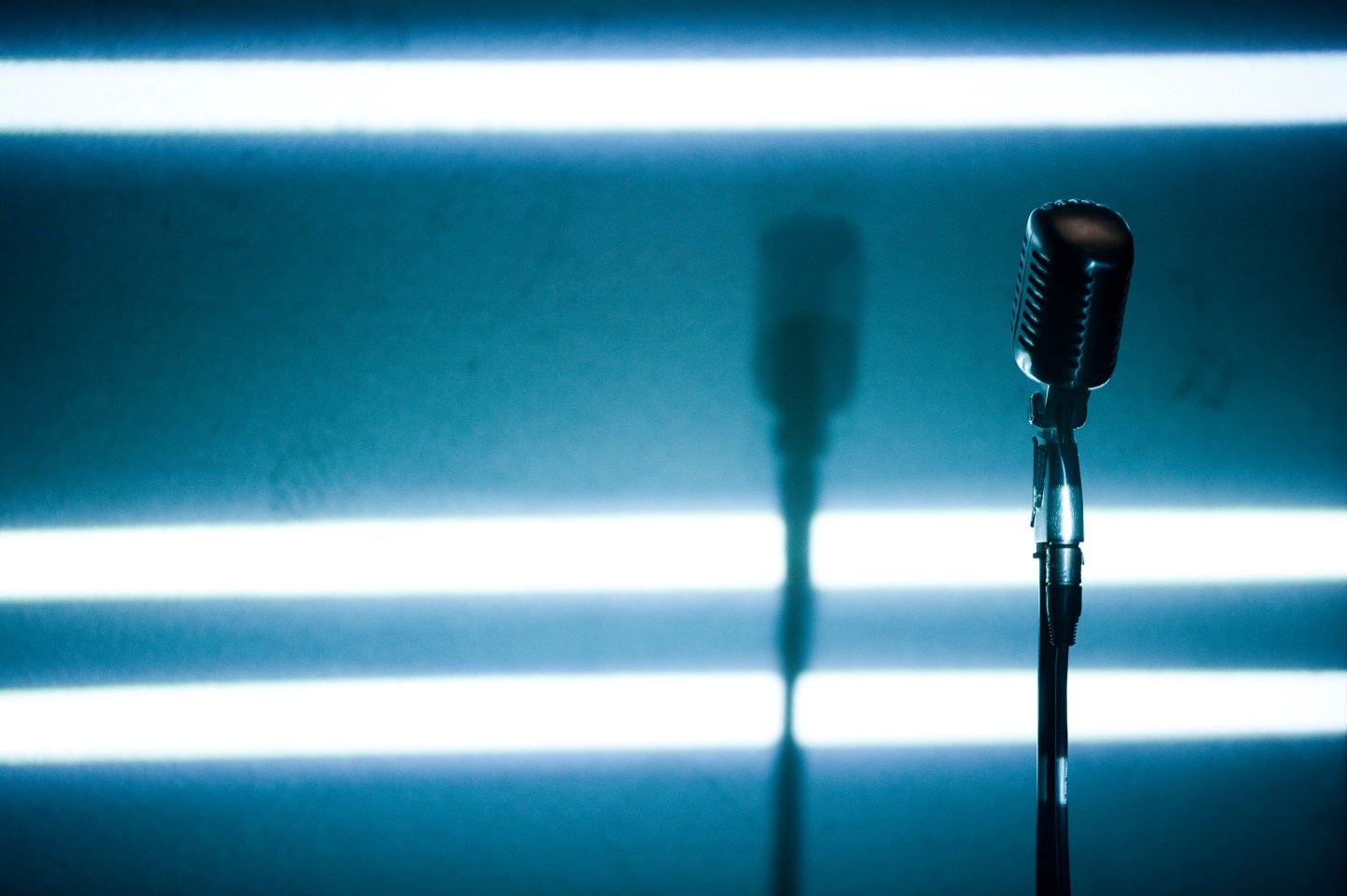A microphone backlit on a stage