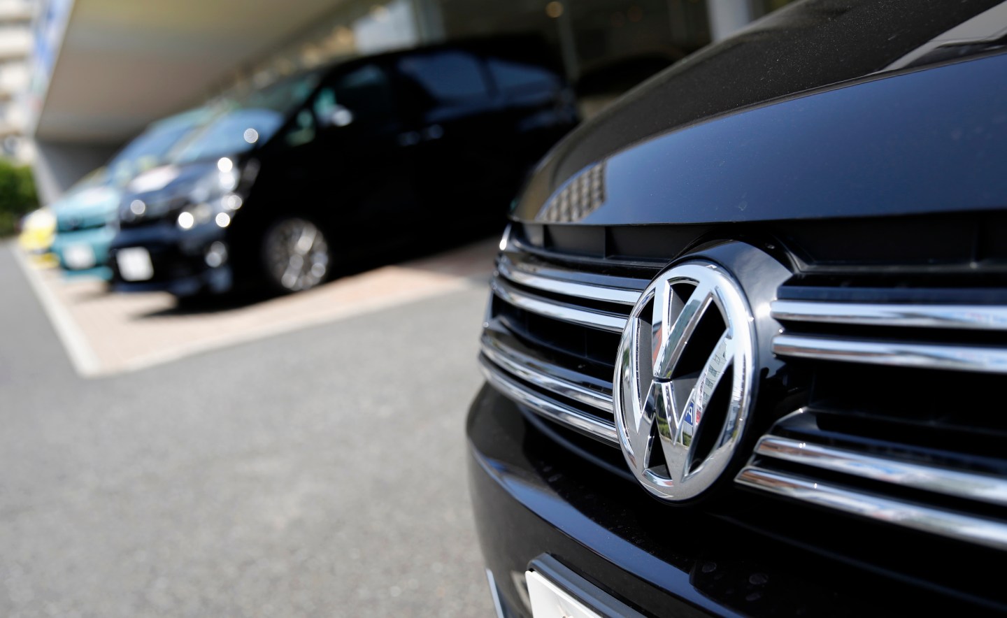 A Volkswagen car is seen in front of Toyota Motor Corp cars at their dealership in Tokyo