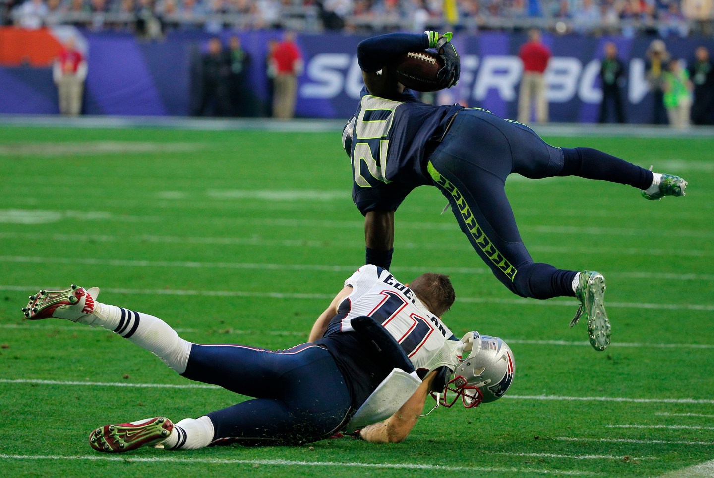 Seattle Seahawks cornerback Lane is tackled by New England Patriots wide receiver Edelman after making a first quarter interception during the NFL Super Bowl XLIX football game in Glendale