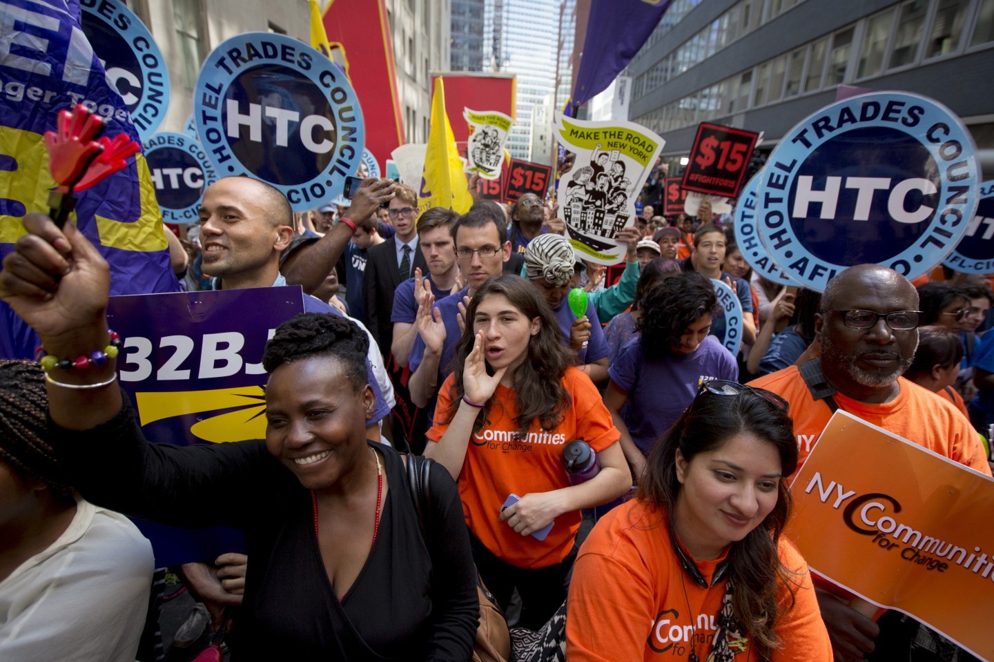 People celebrate the passage of the minimum wage for fast-food workers by the New York State Fast Food Wage Board during a rally in New York