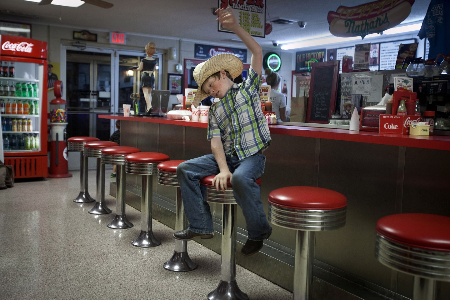Clay Guiton, 9, spins on a bar stool as he pretends to be riding a bull while he waits for his parents to leave a restaurant in Troutman