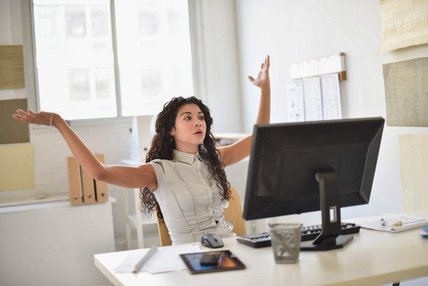 Mixed race businesswoman frustrated at computer at desk in office