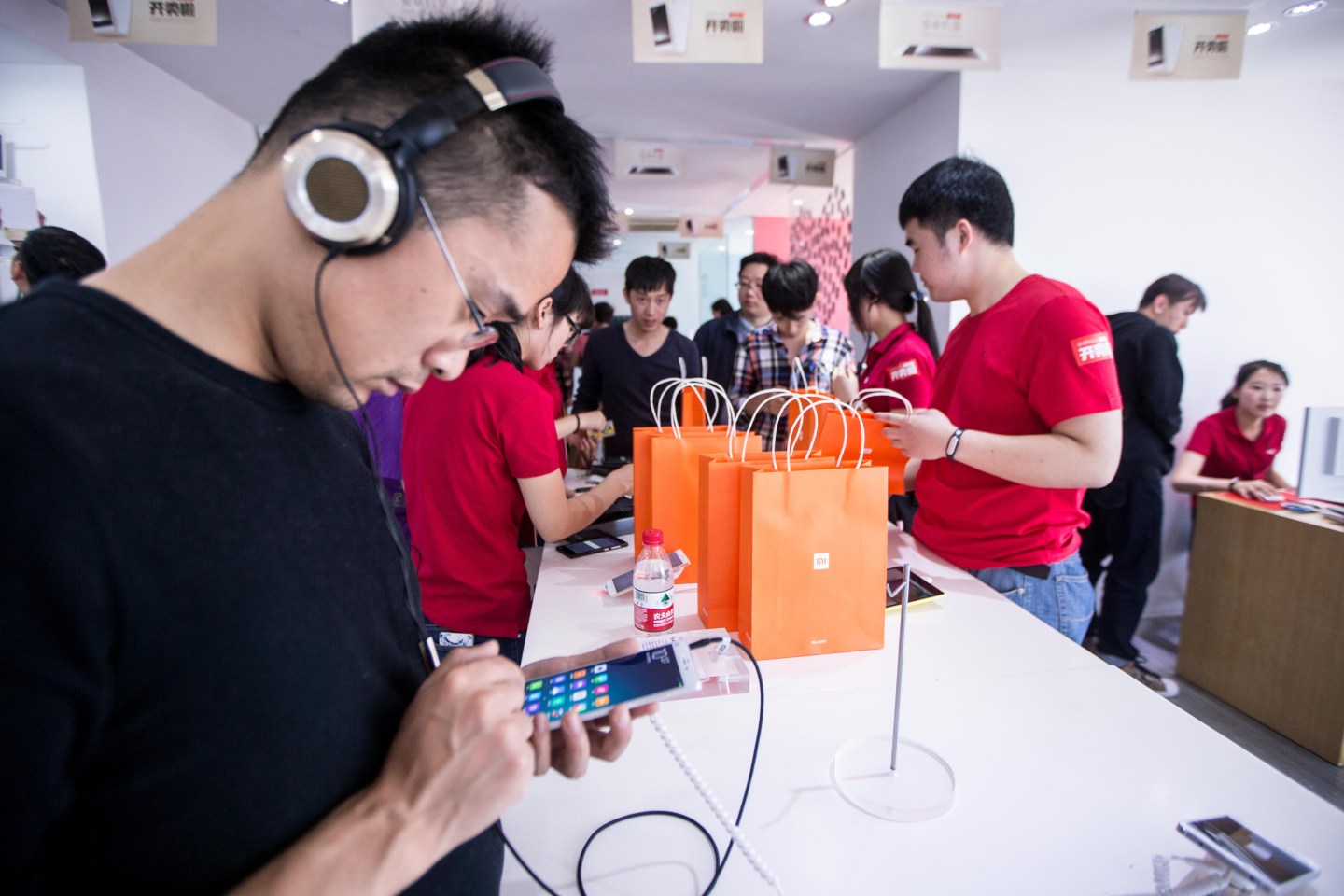 Customers look at Xiaomi phones at a Xiaomi experience store on May 12, 2105 in Hangzhou, Zhejiang province of China.