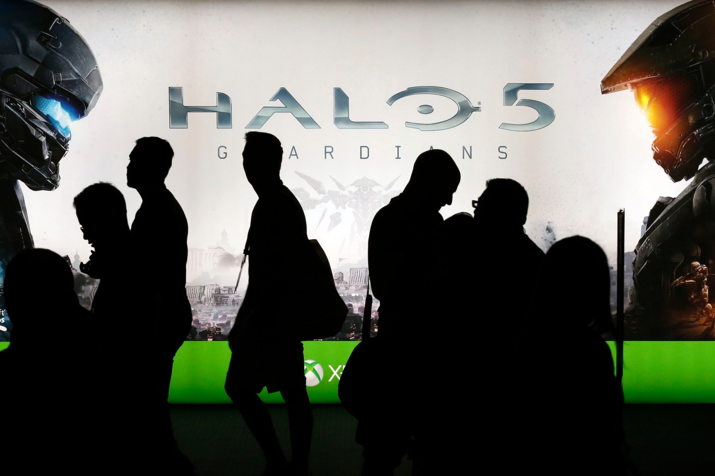 People walk past signage for Microsoft's Halo 5: Guardians game.